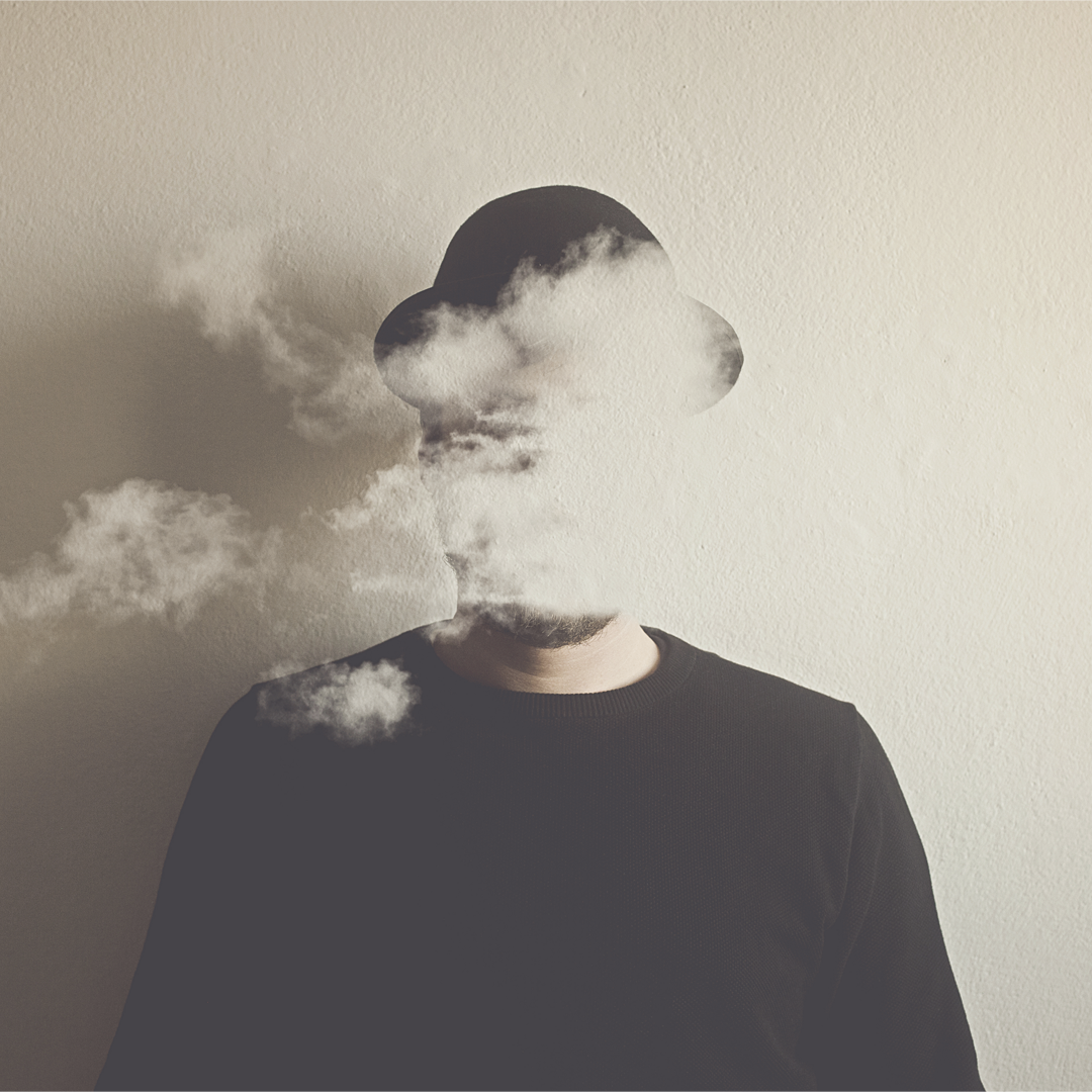 Homme avec fumée sur le visage et un chapeau noir 